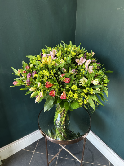 Bonnie Connie - The Bonnie Connie vase arrangement is made up of a rainbow range of Alstroemerias and mixed foliage, delivered in a glass vase making it an eco friendly design.

Alstroemerias also known as Peruvian Lily offer a good vase life, clusters of delicate, trumpet shaped flowers on the end of short flower stalks that spray off of a single stem. In a variety of colours, purple, pink, dark pink, white, yellow, red, orange, and rust. Most colours are freckled or streaked with contrasting colours. Alstroemerias are often associated with friendship, love, and devotion

Product shown is the medium size